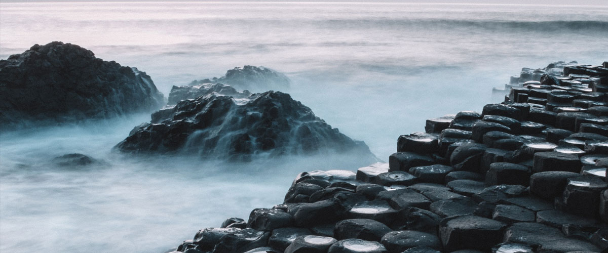 Giants Causeway - the famous hexagonal stones with water and mist creating an atmospheric scene
